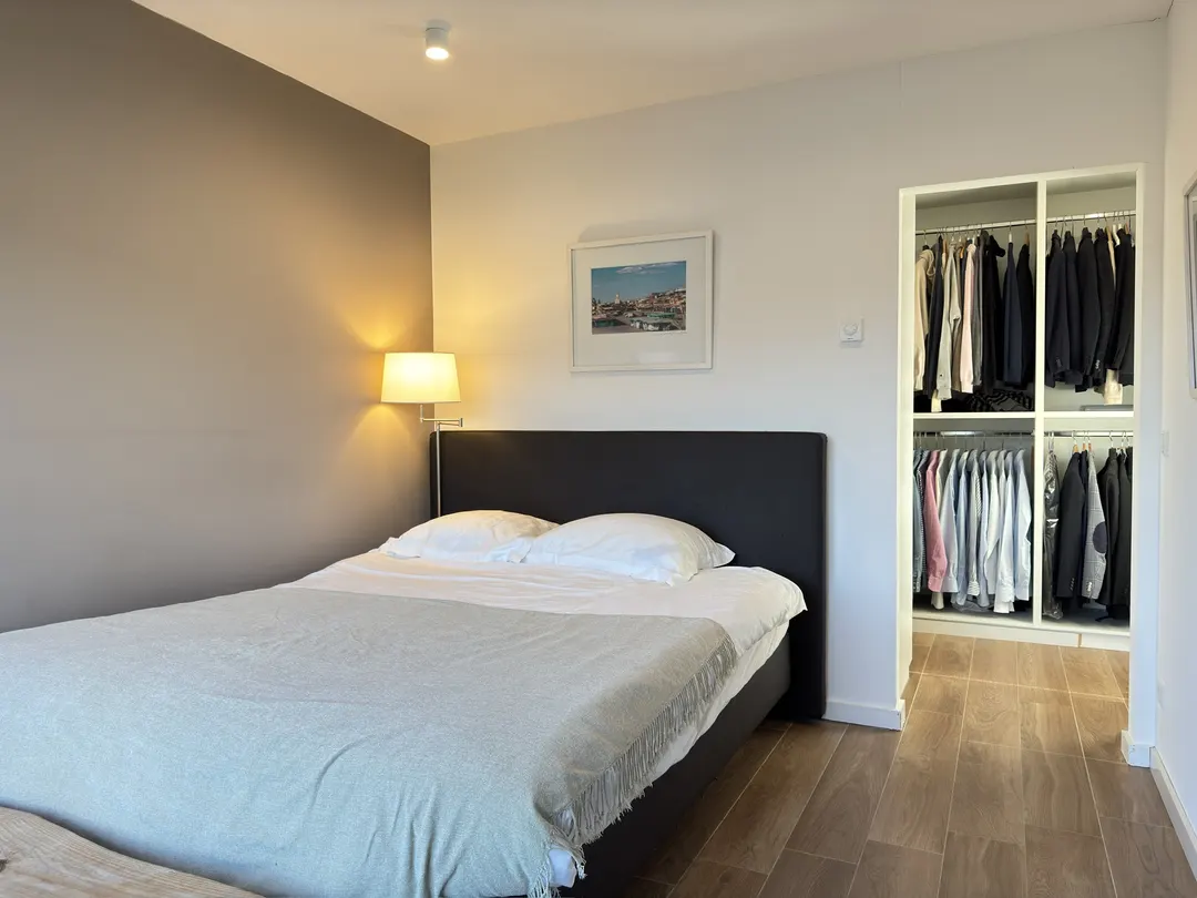 Chambre avec lit, appliques murales et dressing ouvert