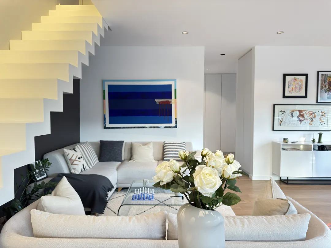 Escalier blanc en Corian à main courante éclairée, vu du séjour