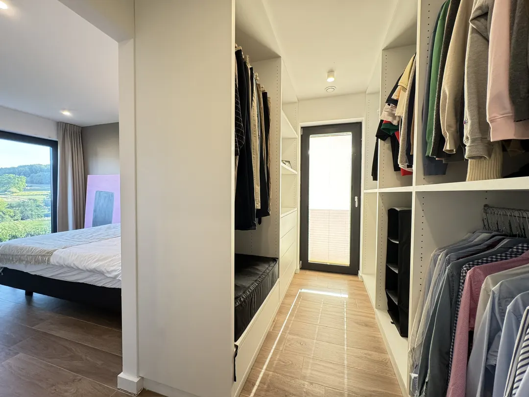 Dressing avec penderies et étagères des deux côtés, porte vitrée au fond