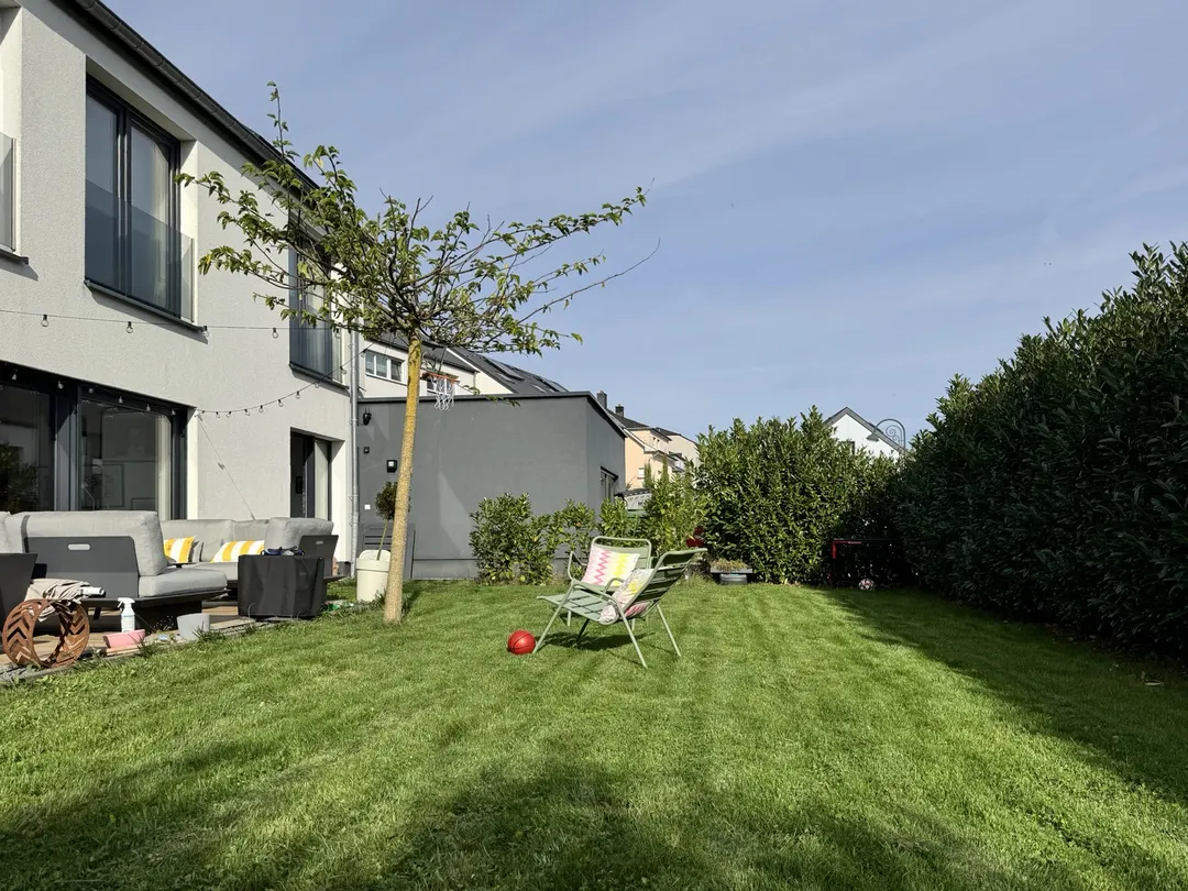 Pelouse le long de la haie, terrasse et façade à gauche
